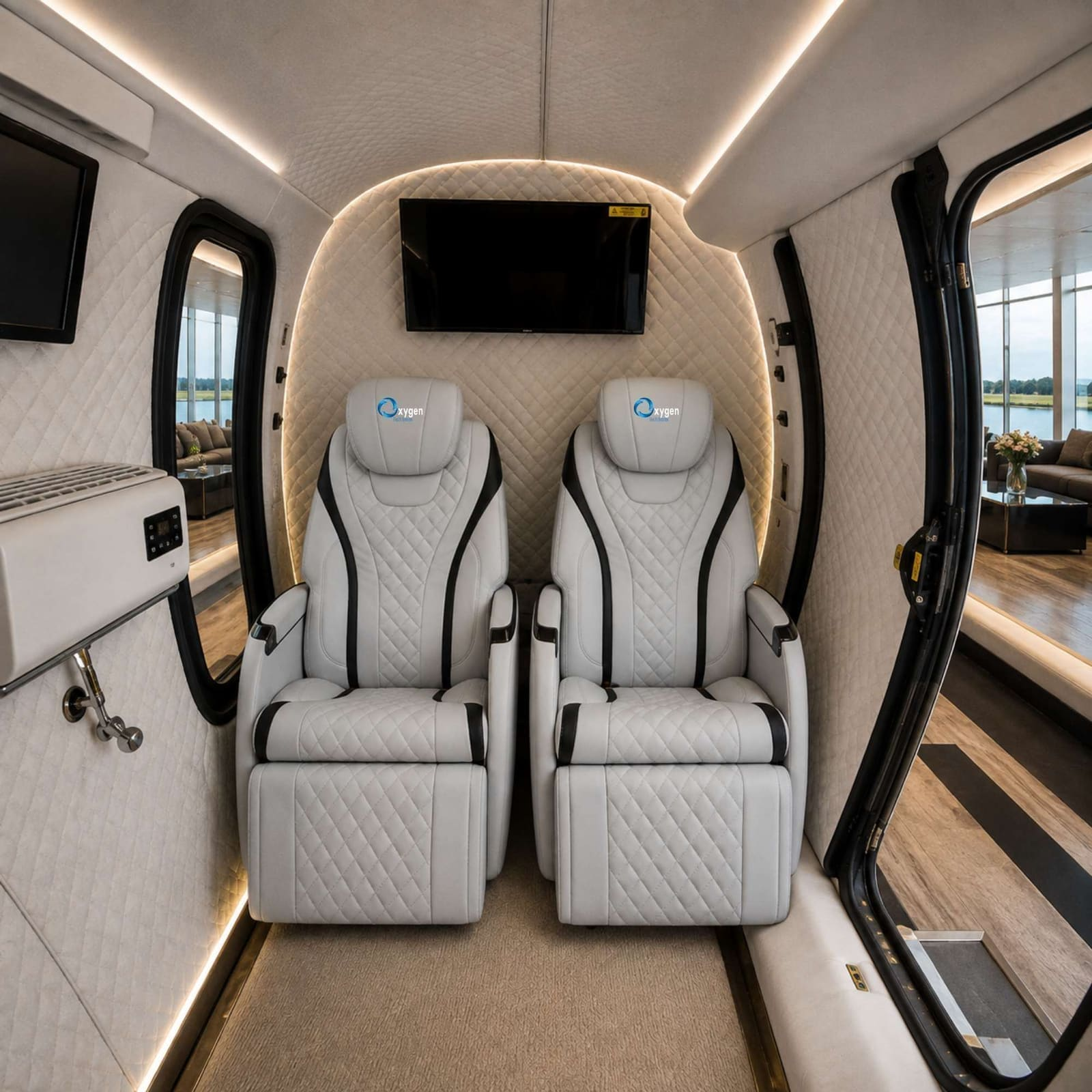 Interior of the ESX64 multiplace hyperbaric chamber with two quilted leather reclining seats and a mounted TV
